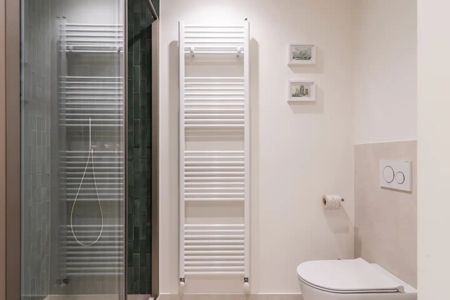 Secondo bagno con doccia in piastrelle verdi, porta vetro, scaldasalviette a scala e sanitari sospesi
