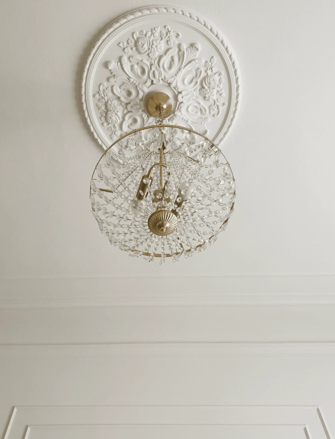 Primo piano del lampadario di cristallo con rosone decorativo a soffitto