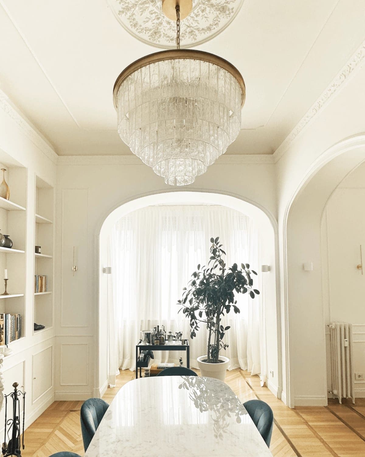Grande lampadario a cascata di cristallo sotto soffitto bianco ad arco