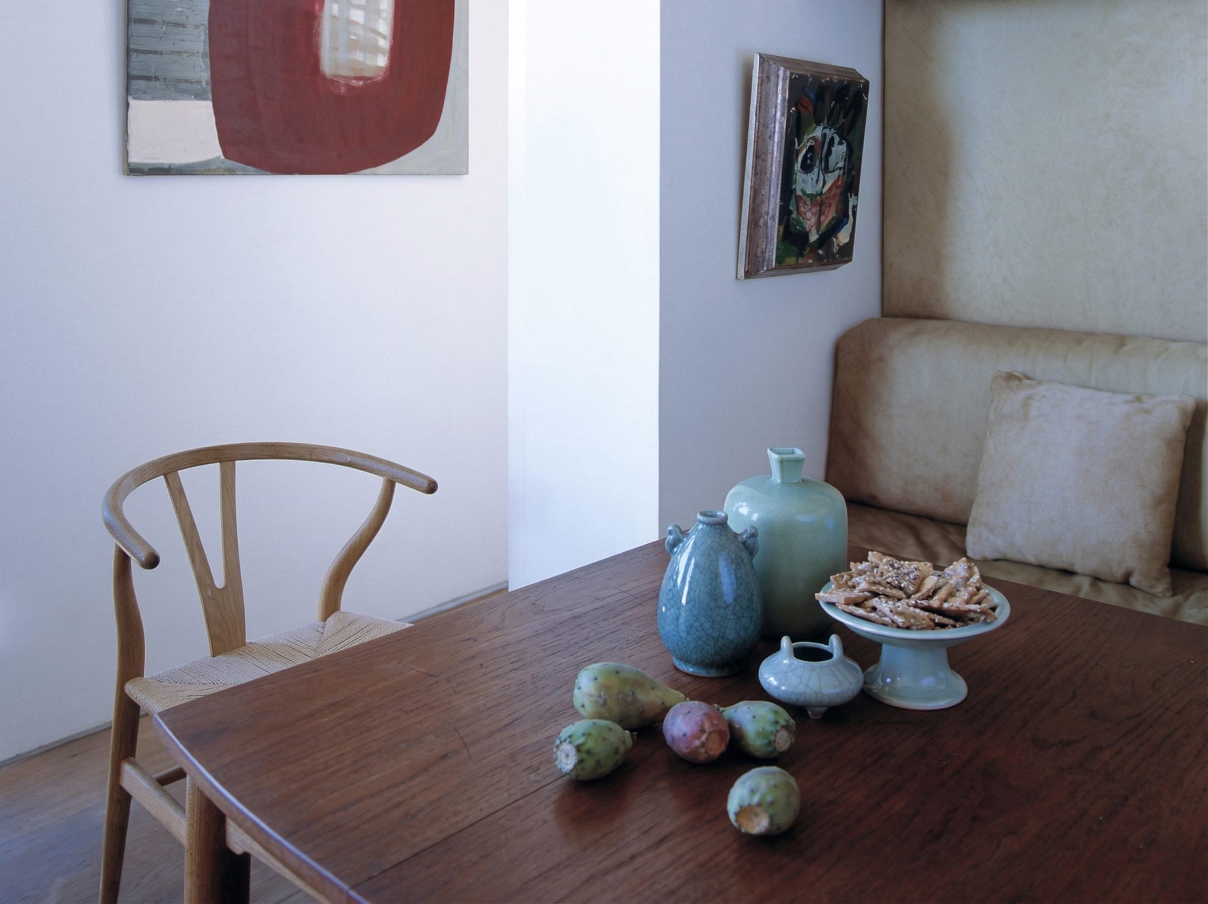 Sala da pranzo con tavolo, sedia Wishbone, ceramiche e quadri a parete